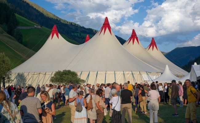 Zahlreiche Besucherinnen und Besucher vor dem Zirkuszelt des Hoch Kultur Festivals in Innervillgraten.