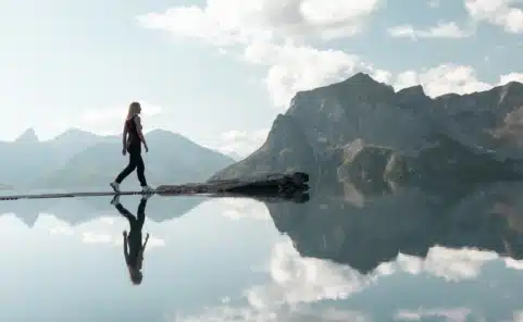 Besucherin auf den Trittsteinen des Lech Mountain Mirror bei der Zugerbergbahn in Lech am Arlberg