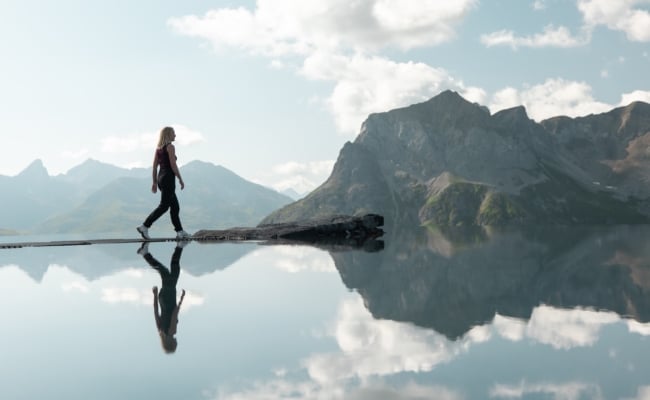 Besucherin auf den Trittsteinen des Lech Mountain Mirror bei der Zugerbergbahn in Lech am Arlberg