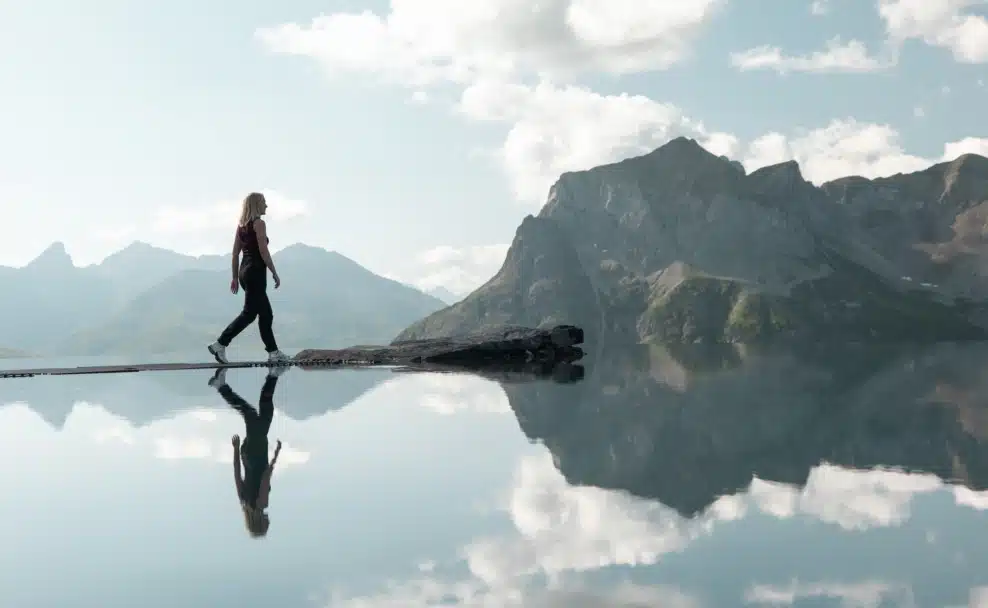 Besucherin auf den Trittsteinen des Lech Mountain Mirror bei der Zugerbergbahn in Lech am Arlberg