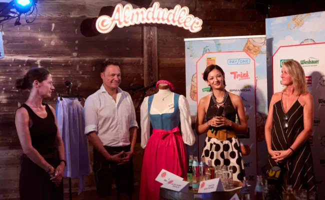 Das neue Wiener Kaiser Wiesn Dirndl Mizzi wird auf einer Bühne in der Almdudler Alm präsentiert