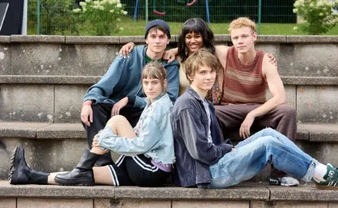 Die fünf Hauptdarsteller von „Club der roten Bänder – Die neue Generation“ sitzen gemeinsam auf Stufen.
