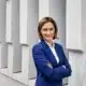 ZDF-Chefredakteurin Bettina Schausten im blauen Hosenanzug vor einer Betonfassade