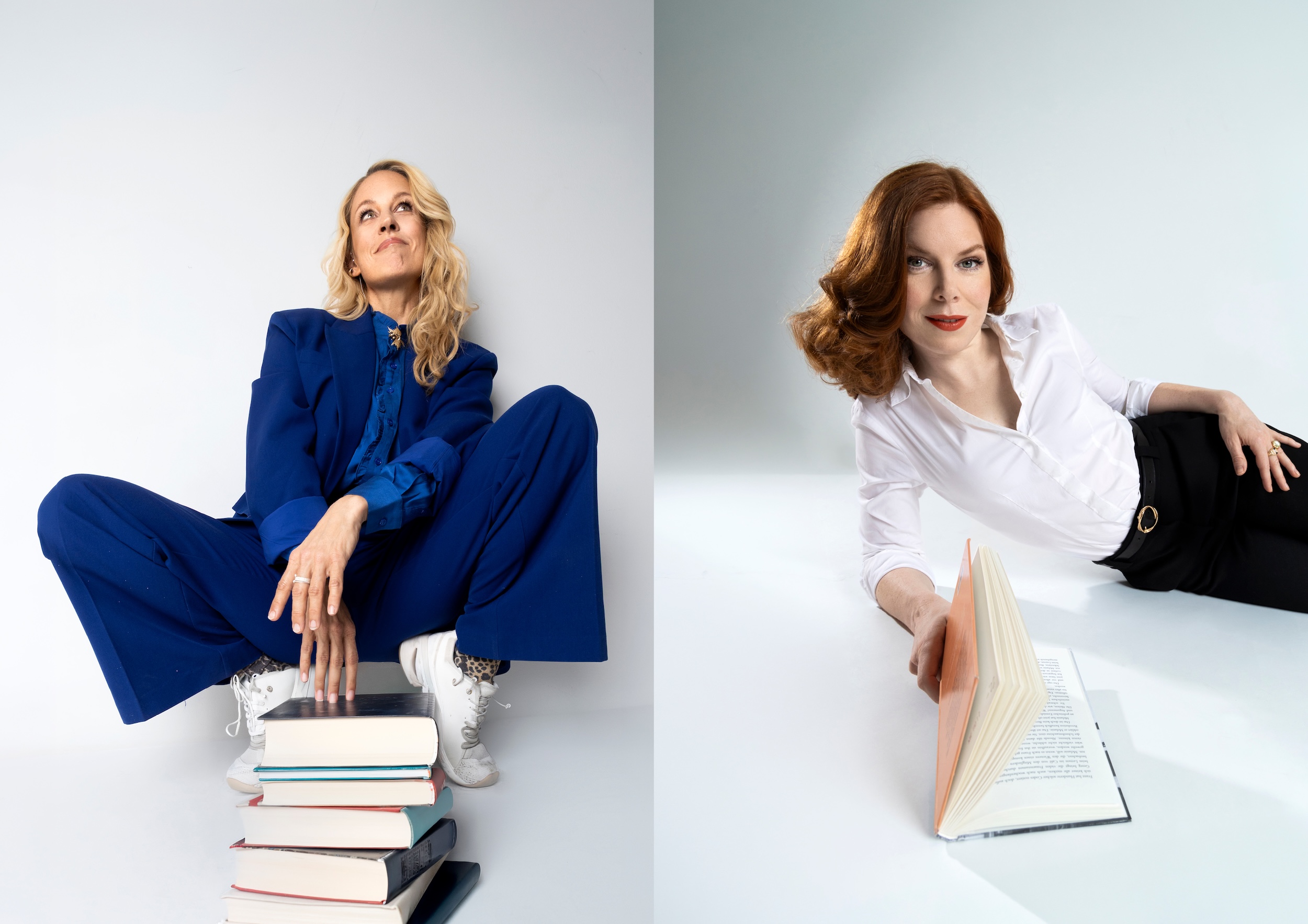 Lilian Klebow im blauen Anzug hinter einem Bücherstapel und Teresa Vogl in weißer Bluse mit einem aufgeschlagenen Buch.