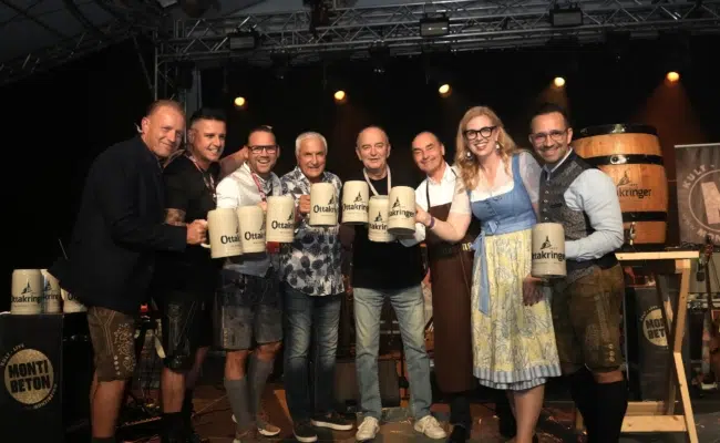 Acht Gäste stehen mit Ottakringer-Maßkrügen auf der Bühne bei der Eröffnung der Brunner Wiesn.