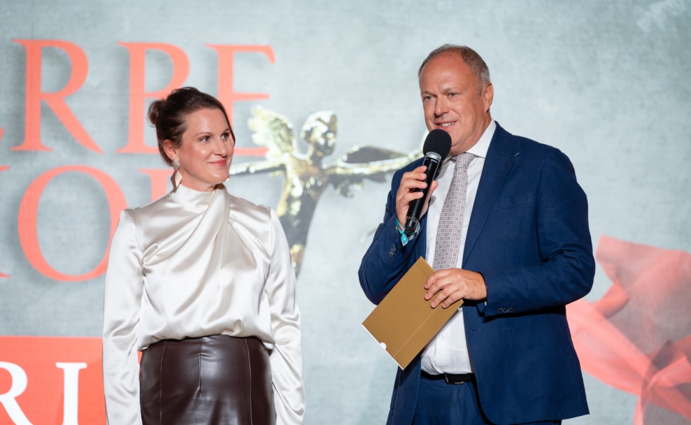 Elisabeth Laimighofer und Richard Grasl auf der Werbe-Amor-Bühne; Grasl spricht ins Mikrofon.