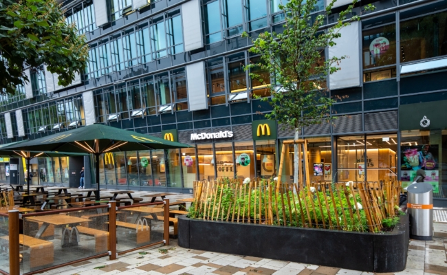 Außenansicht des McDonald’s Restaurants am Handelskai 92 mit Terrasse am Maria-Restituta-Platz in Wien.
