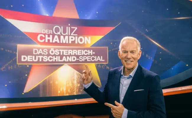 Johannes B. Kerner vor dem Schriftzug „Der Quiz-Champion – Das Österreich-Deutschland-Special“.
