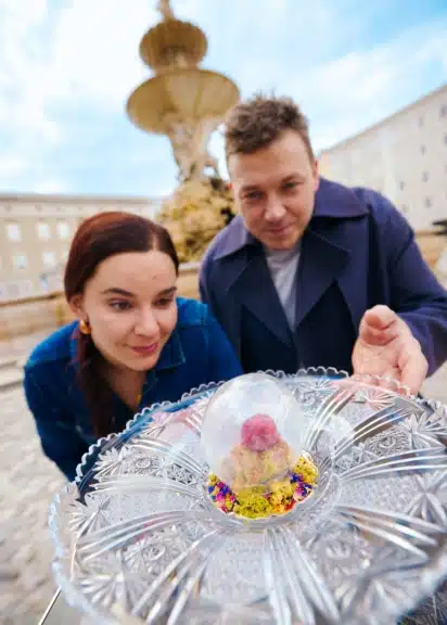 Julia Zotter und Philip Rachinger präsentieren eine Zuckerglaskugel mit Sauerkirsche und Schoko-Lebermousse.