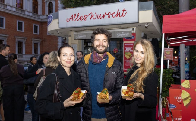 Nadja May, Aaron Karl und Fiona Ristl halten Nacho Dogs vor dem Würstelstand „Alles Wurscht“.
