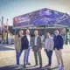Fünf Männer vor der erhöhten, über Eck angeordneten LED-Werbefläche mit einer Suzuki-Swift-Kampagne am Wiener Riesenradplatz.