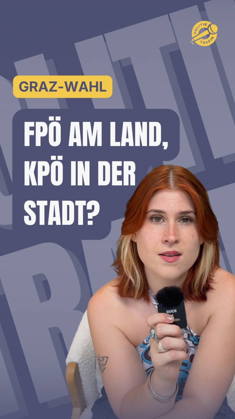 Julia Hanusch hält ein Mikrofon vor einem violetten Hintergrund mit Politiktrafik-Logo und der Aufschrift „Graz-Wahl: FPÖ am Land, KPÖ in der Stadt?“.