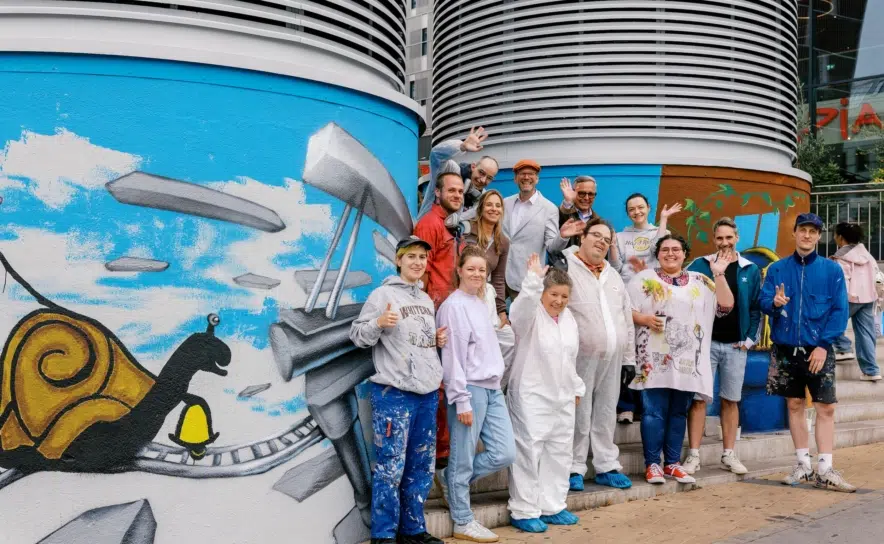 Kunstschaffende und Projektbeteiligte beim Street-Atelier am Europaplatz. Für „Bunte Türme für die Nachbarschaft“ wurden vier Lüftungstürme beim Wiener Westbahnhof gemeinsam gestaltet.