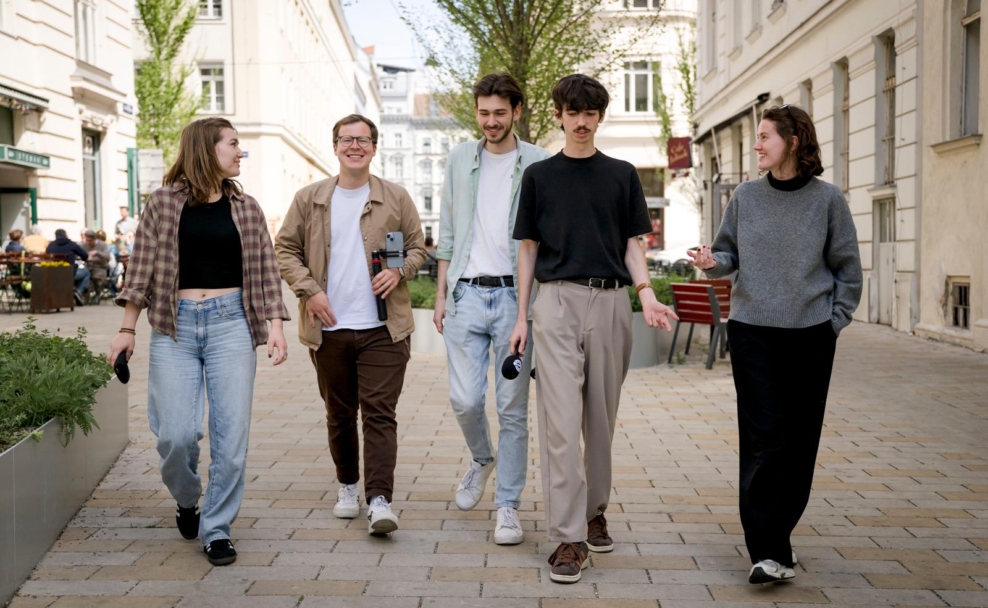 Fünf Mitglieder des Politiktrafik-Teams gehen durch eine Wiener Straße. Jakob Gartner und Konstantin Schinagl sind neben weiteren Teammitgliedern zu sehen.